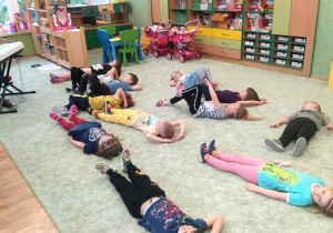 Dzieci odpoczywają na dywanie.
